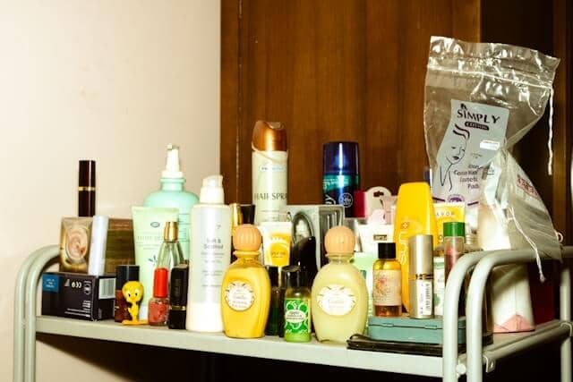 Crowded shelf with assorted skincare, makeup, and personal care products in disarray