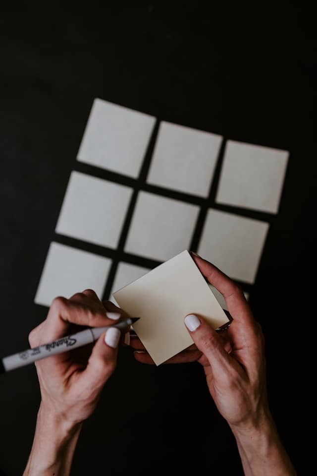Preparing labels to store seasonal decor with organized notes and a marker on sticky notes
